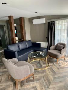 a living room with a blue couch and two chairs and a table at Istanbul Park Hotel in Tuzla
