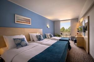 a hotel room with two beds and a balcony at Valamar Diamant Hotel in Poreč