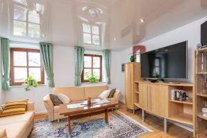 a living room with a couch and a tv at Ferienwohnung Nesselbachtal in Neustadt an der Aisch