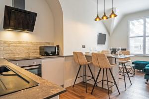 a kitchen with a counter and stools in a room at Watergate Penthouse - NEW 2 bed luxury apartment in City Centre in Chester