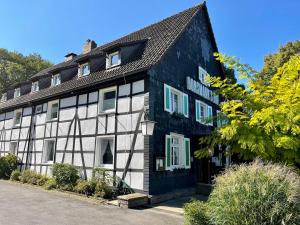 ヘルデッケにあるLandhotel Bonsmann's Hofの白窓のある古い黒と白の建物