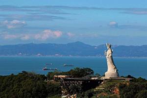 una estatua en la cima de una colina cerca del agua en GOD’S Queen Esther en Nangan