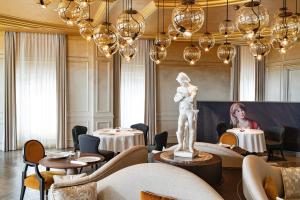 a restaurant with tables and a statue in the middle at Royal Champagne Hotel & Spa in Champillon