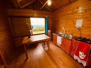 a kitchen with a table and a window in a cabin at Pousada do Belvedere - Sítio Ramos in Praia Grande