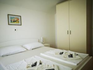 a white bedroom with two towels on a bed at Apartma Čeh in Gabrovica pri Črnem Kalu