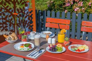 uma mesa vermelha coberta com pratos de comida para o pequeno-almoço em Hotel Oberhausen Neue Mitte affiliated by Meliá em Oberhausen
