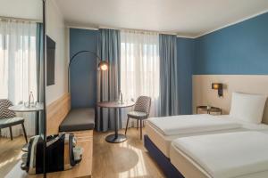 ein Hotelzimmer mit einem Bett und einem Tisch in der Unterkunft Hotel Oberhausen Neue Mitte affiliated by Meliá in Oberhausen + 73 Fotos