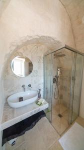 un baño con bañera y ducha de cristal en Martina Trulli Relais, en Locorotondo