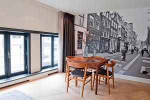 una sala da pranzo con tavolo e sedie di fronte a una finestra di Hotel IX Nine Streets Amsterdam ad Amsterdam