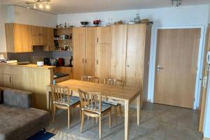cocina con mesa de comedor de madera y sillas en Bel appartement 2.5 pièces avec balcon, magnifique vue sur le glacier des Grands en Finhaut