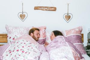 a man and a woman laying in bed at Connyhaus St Oswald ob Eibiswald in Sankt Oswald ob Eibiswald