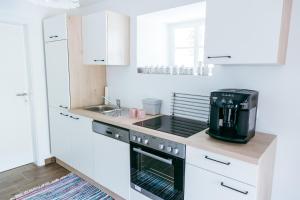 a kitchen with white cabinets and a coffee maker at Connyhaus St Oswald ob Eibiswald in Sankt Oswald ob Eibiswald