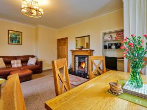 a living room with a table and a fireplace at West Lodge in Bridgend of Lintrathen