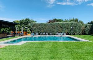 a swimming pool in the middle of a yard with chairs at Istanbul Park Hotel in Tuzla