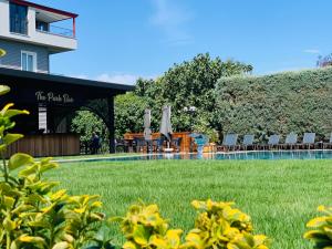 a pool with chairs and umbrellas next to a building at Istanbul Park Hotel in Tuzla
