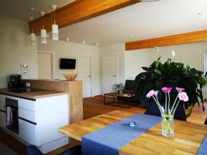 eine Küche und ein Wohnzimmer mit einem Tisch mit Blumen darauf in der Unterkunft Ferienwohnungen BERGfeeling in Bad Mitterndorf