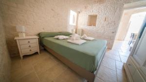 Un dormitorio con una cama con toallas. en Martina Trulli Relais, en Locorotondo