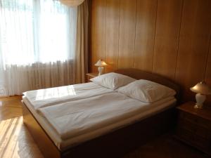 a bedroom with a bed with white sheets and a window at Hotel Wieniawa in Wrocław