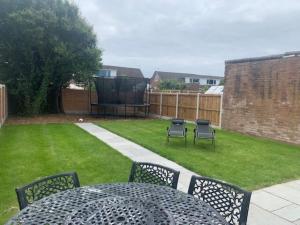 a patio with a table and chairs in a yard at Lovely 3-Bed House in Lytham Saint Annes in Saint Annes on the Sea