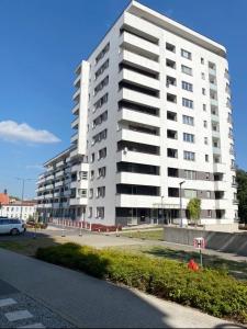 - un grand immeuble blanc avec un parking dans l'établissement Ultra Apartments Nautica, à Szczecin