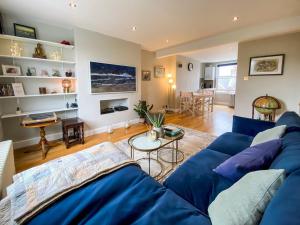 a living room with a blue couch and a table at Pass the Keys Immaculate flat with roof terrace in North London in London