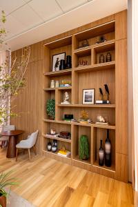 Habitación con estanterías de madera con jarrones y silla en K-Platz Hotel en São José