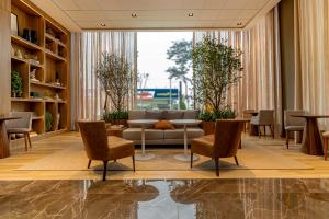 eine Lobby mit Sofa, Stühlen und einem Tisch in der Unterkunft K-Platz Florianópolis São José in São José + 118 Fotos