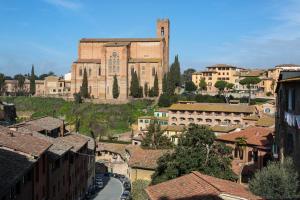 vistas a una ciudad con iglesia y edificios en Hotel Alma Domus en Siena