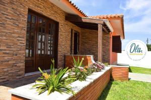 a brick retaining wall with flowers in front of a house at OLA Guesthouse in Esmoriz