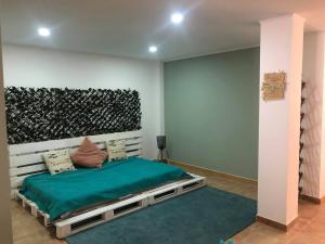 MiaMar House Sesimbra في سيسيمبرا: غرفة نوم بسرير وبطانية خضراء