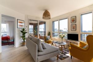un soggiorno con divano e TV di Le Manhattan - Grand 3 chambres - Vue panoramique a Nantes