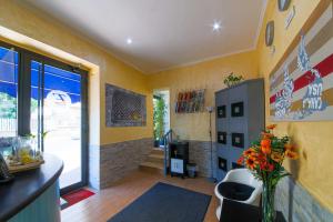 ein Wohnzimmer mit gelben Wänden und einer Vase aus Blumen in der Unterkunft E-Room 42 in Rom