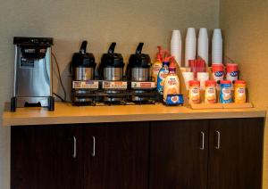 a counter top with a coffee maker and condiments at Red Roof Inn Dayton - Fairborn/Nutter Center in Fairborn