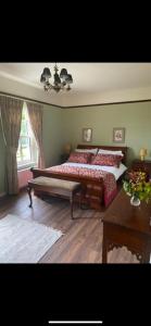 a bedroom with two beds and a table at Yellow Heights Accommodation in Tinahely