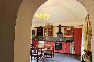a kitchen with red cabinets and a table and chairs at Yellow Heights Accommodation in Tinahely