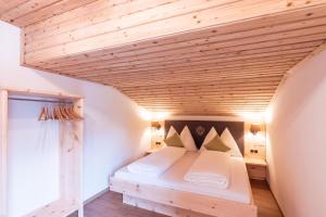 een bed in een kamer met een houten plafond bij Haus Rabl in Itter