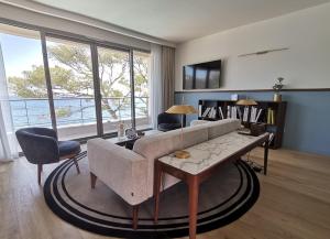 卡西斯Hôtel Les Roches Blanches Cassis的带沙发和桌子的客厅
