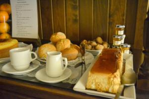 a table with coffee cups and bread and pastries at Hotel Brisa in A Coruña