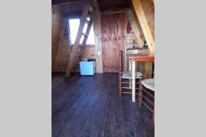 an attic room with wooden floors and a window at Cabaña Pirayú in Oliveros