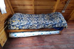 a bed in a room with a quilt on it at Cabaña Pirayú in Oliveros