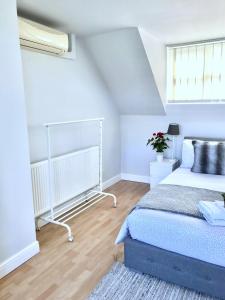 a white bedroom with a bed and a window at Fox View Guesthouse in Bristol