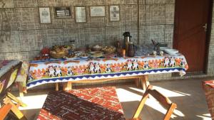 une table avec une nappe sur laquelle se trouve de la nourriture dans l'établissement Pousada Reis, à Pirenópolis