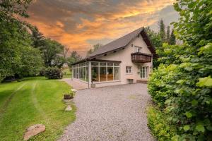 a white house with a large window in a yard at Logement de Blauwe Reiger in Voeren