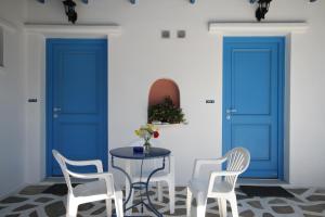 ein Esszimmer mit blauen Türen und einem Tisch mit Stühlen in der Unterkunft Vrahia Studios in Agiassos