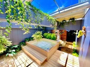 a hot tub on a patio with plants at Capsule Inn Osaka (Male Only) in Osaka