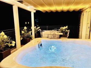 a jacuzzi tub on a balcony with flowers at Dimora di Charme Rooms & Apartments in Peschiera del Garda