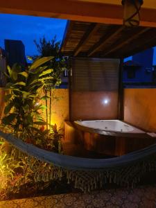 a hammock outside of a building with a bath tub at Pousada Vila Rosada in Florianópolis