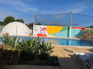 a swimming pool with a large mural next to a building at Solmeco Park in Aldeia do Meco
