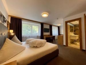 a hotel room with a bed with white pillows at Haus Steffeler in Sankt Anton am Arlberg