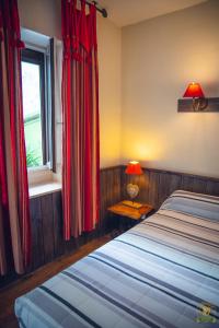 a bedroom with two beds and a window with red curtains at The Liberty's in Villefranche-sur-Saône